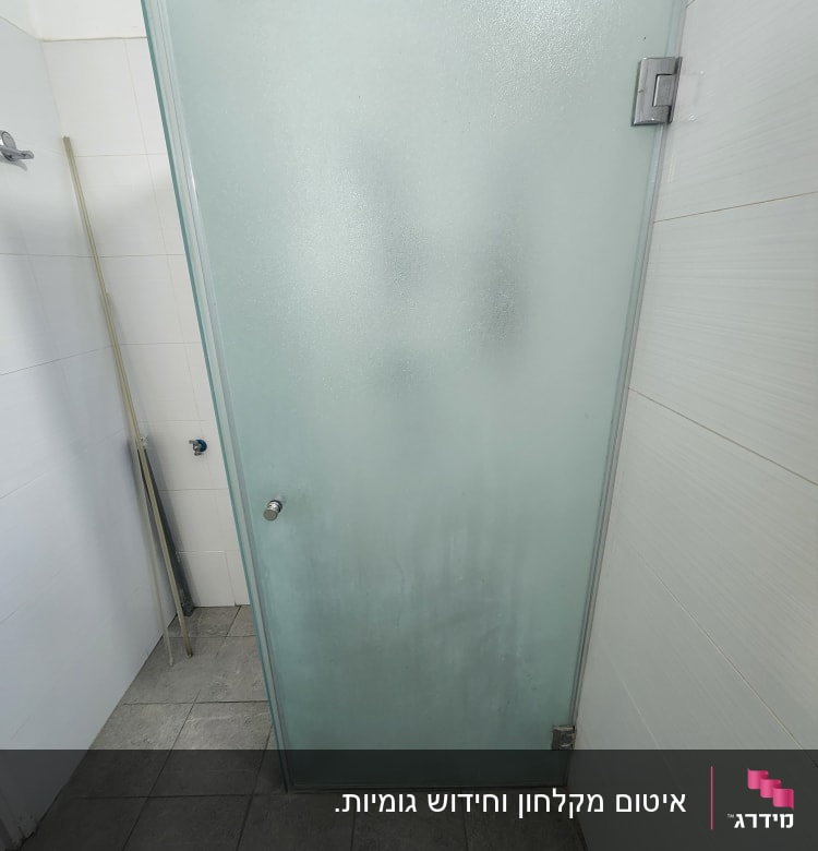 דלת זכוכית חלבית במקלחת עם ידית מתכת